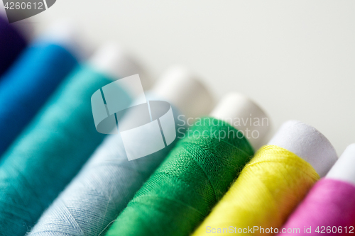 Image of row of colorful thread spools on table