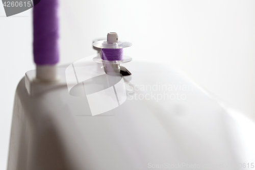 Image of thread spools on sewing machine