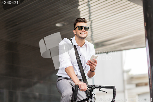 Image of man with bicycle and smartphone on city street