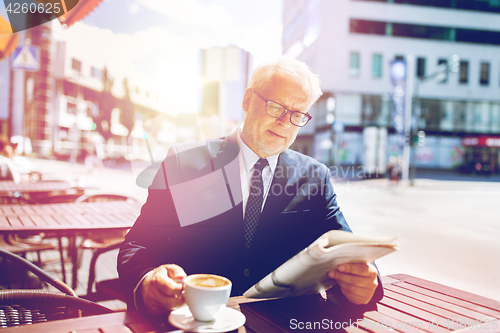 Image of senior businessman with newspaper drinking coffee