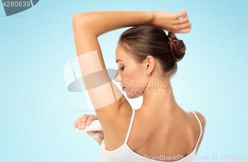 Image of woman with antiperspirant deodorant over white