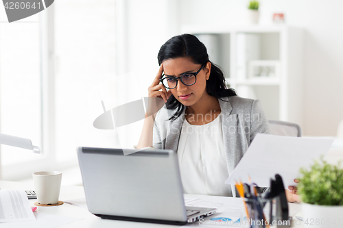 Image of stressed businesswoman with laptop at office