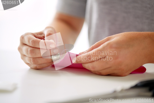 Image of woman with needle stitching fabric pieces