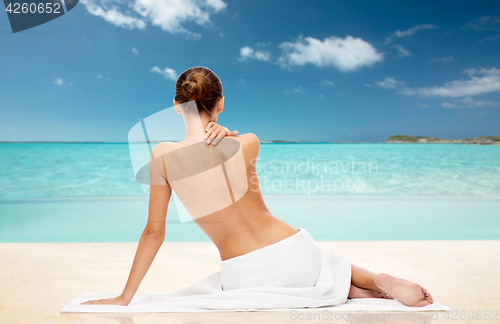 Image of beautiful woman in towel with bare top on beach