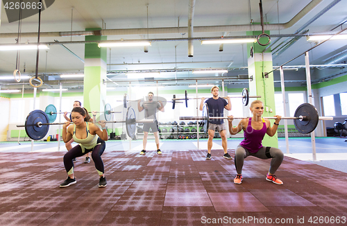 Image of group of people training with barbells in gym