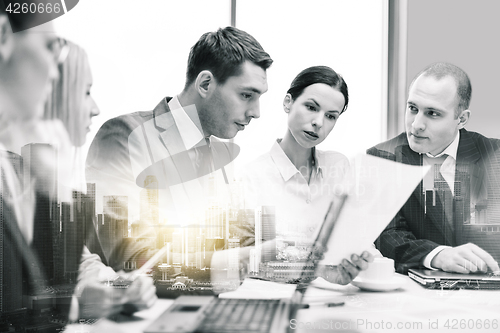 Image of business team with laptop and papers at office