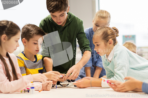 Image of happy children building robots at robotics school