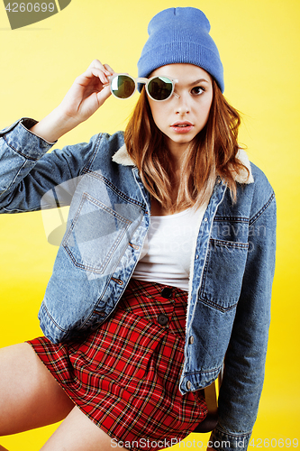 Image of young pretty teenage woman emotional posing on yellow background, fashion lifestyle people concept
