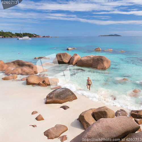 Image of Woman enjoying Anse Lazio picture perfect beach on Praslin Island, Seychelles.