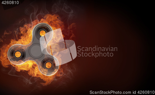 Image of Fidget spinner in fire isolated on black background banner.