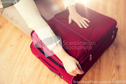 Image of close up of woman packing travel bag for vacation