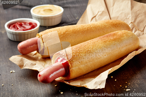 Image of Two hotdogs on wooden table