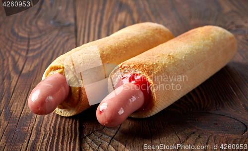 Image of two hotdogs on wooden table