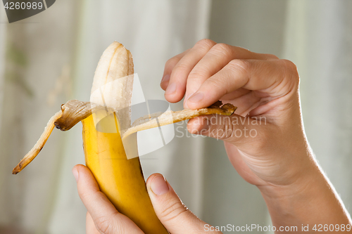 Image of hands peeling a banana