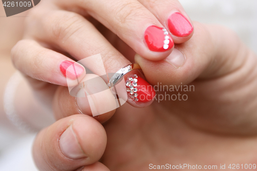 Image of putting a ring on finger of bride