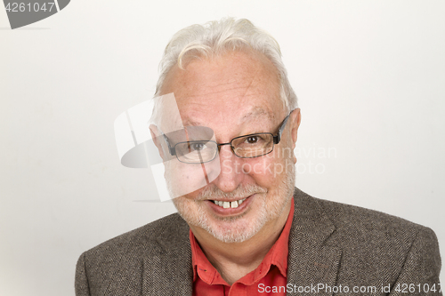 Image of Elderly person with glasses and full beard smiling pleased