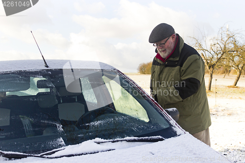 Image of Senior remove car from hoarfrost