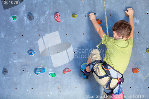 Image of little boy climbing a rock wall