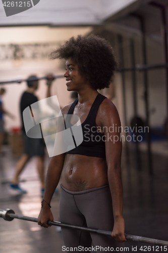Image of black woman lifting empty bar