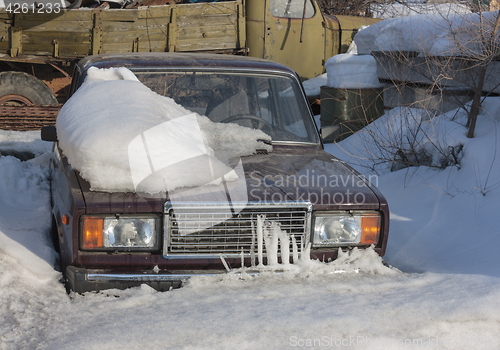 Image of Snow-covered car in the parking lot urban scene after a snowstorm