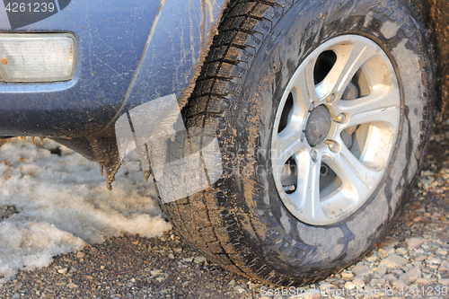 Image of Car tires dirt road in winter snow and ice