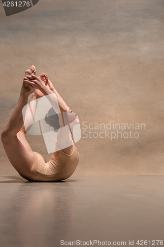 Image of The female ballet dancer posing over gray background