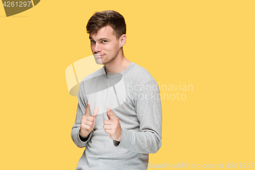 Image of The young man smiling and looking and pointing at cameraaway