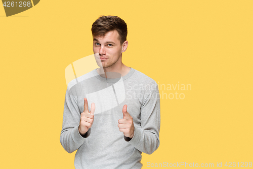 Image of The young man smiling and looking and pointing at cameraaway