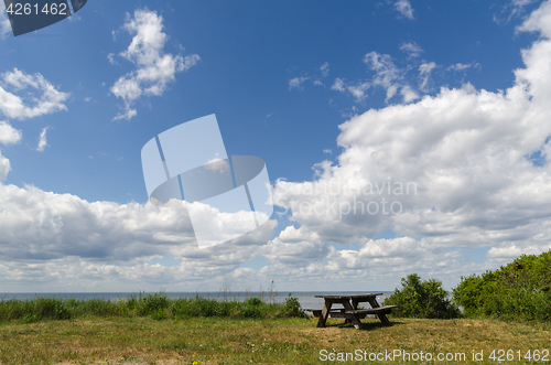 Image of Wooden bench and table by the coast