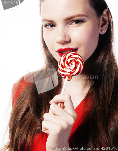 Image of young pretty brunette girl with red candy posing on white background isolated