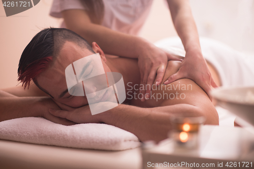 Image of young man having a back massage