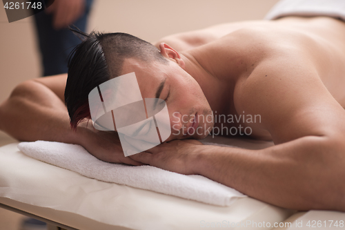 Image of handsome man resting in a spa massage center