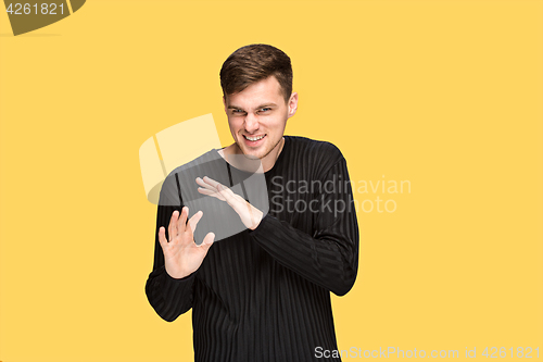 Image of The young man pointing to something and looking at camera