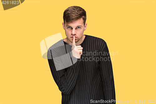 Image of The young man pointing to something and looking at camera