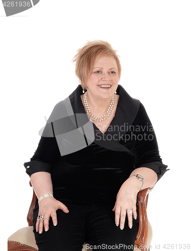 Image of Senior woman relaxing in armchair.