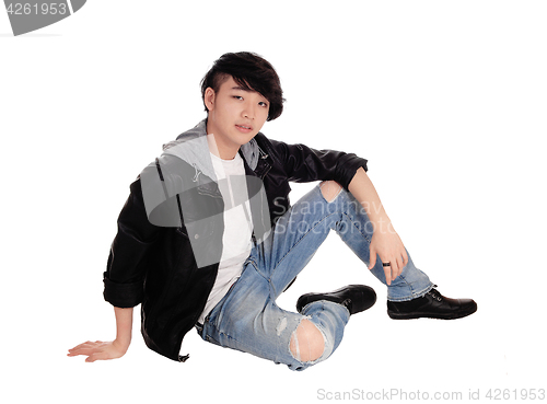 Image of Young Asian man sitting on floor.