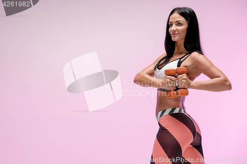 Image of The woman training against pink studio