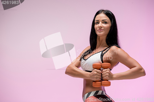 Image of The woman training against pink studio