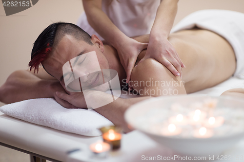 Image of young man having a back massage