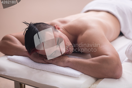 Image of handsome man resting in a spa massage center