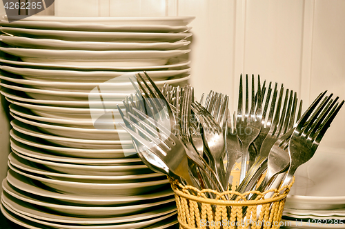 Image of A stack of washed dishes and forks in the kitchen