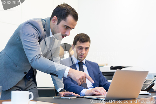 Image of Business team remotely solving a problem at business meeting using laptop computer and touchpad.