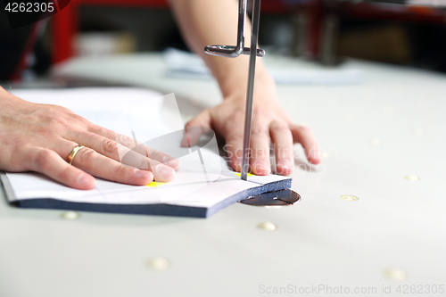 Image of Cutting room, cutting cloth tailoring knife. 