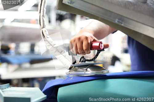 Image of Presser in sewing clothes pressed. 