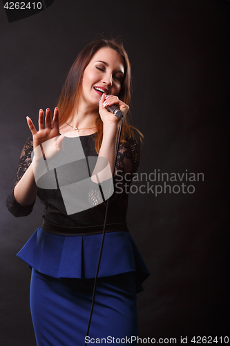 Image of Singer in dress with microphone