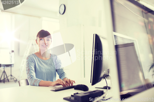 Image of happy asian woman with computer at office