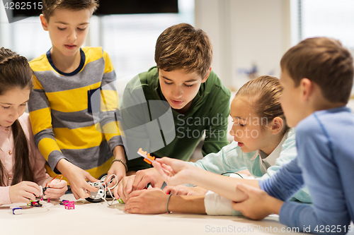 Image of happy children building robots at robotics school