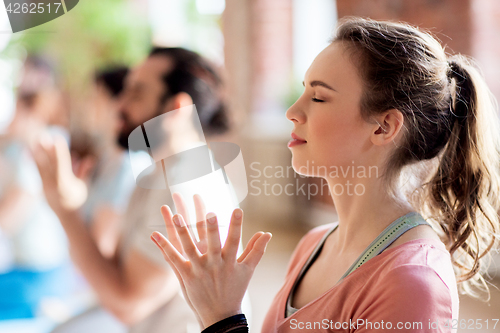 Image of woman with group meditating at yoga studio