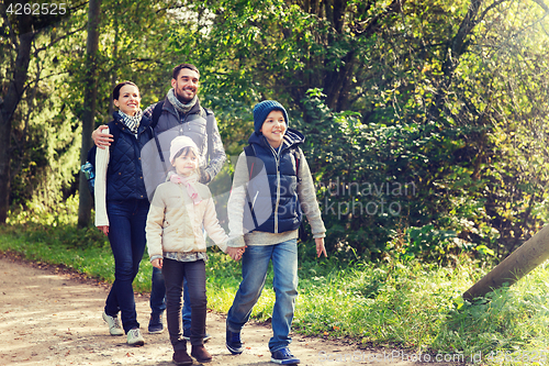 Image of happy family with backpacks hiking in woods