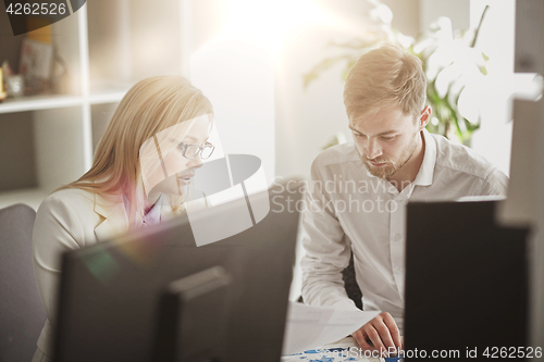 Image of business team discussing papers at office table